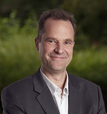 Jan Craps headshot, with green background