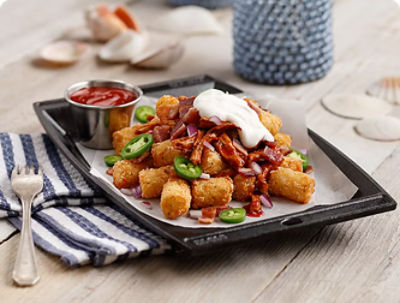 Tater puffs plated FOH with jalapenos, onions, and other toppings