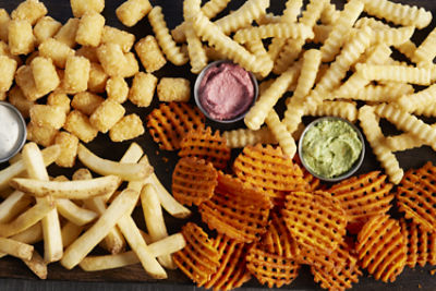fries on dark background with ramekins with dipping sauces