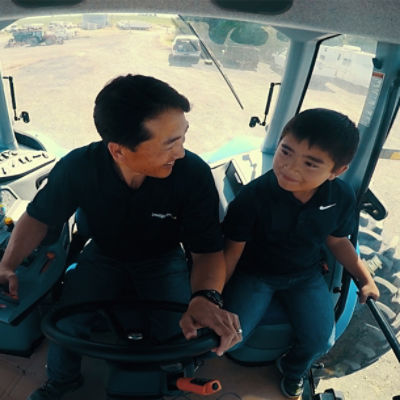 Man and son driving tractor